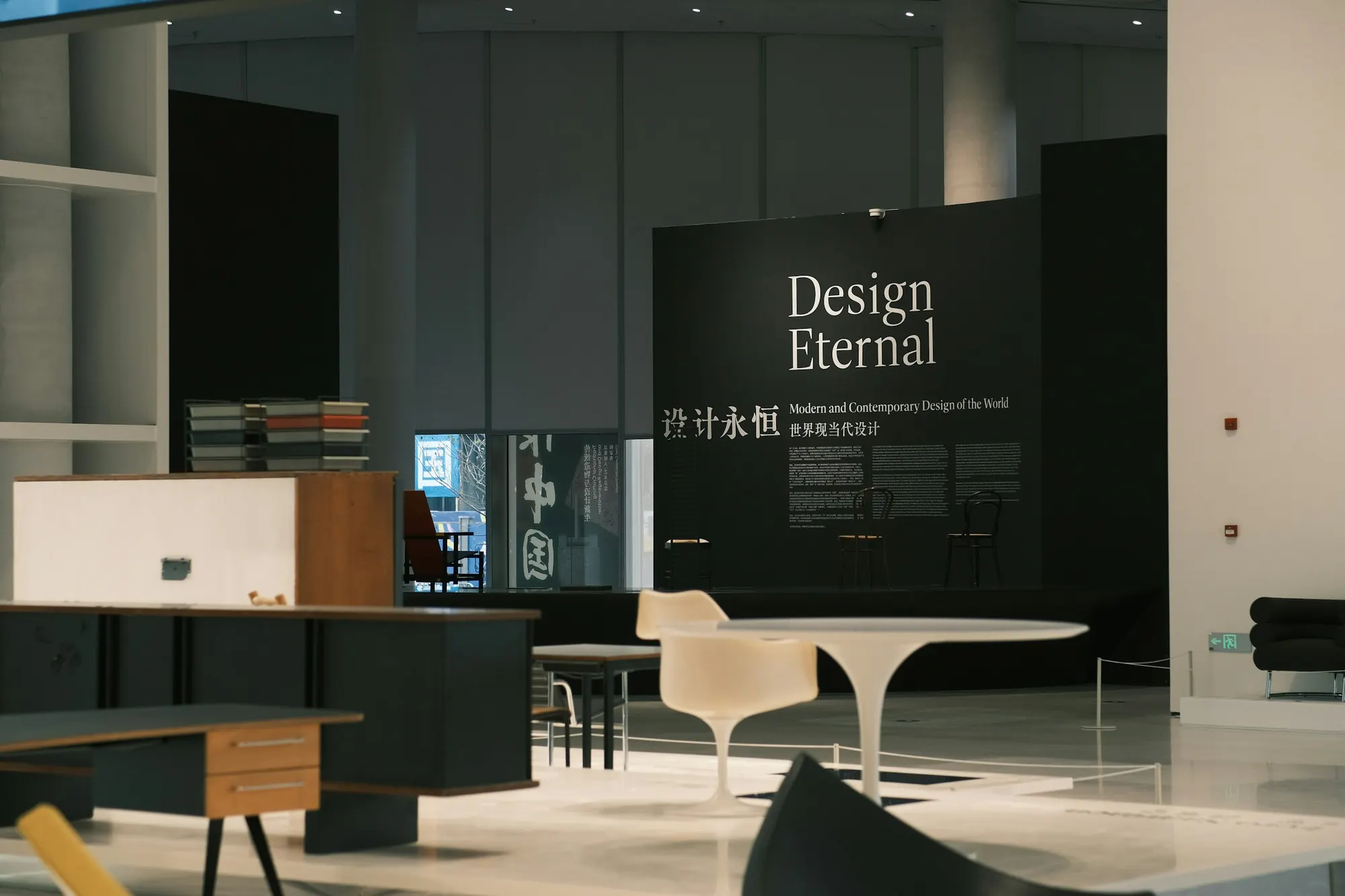 Exhibition stand with a dark feature wall and display furniture