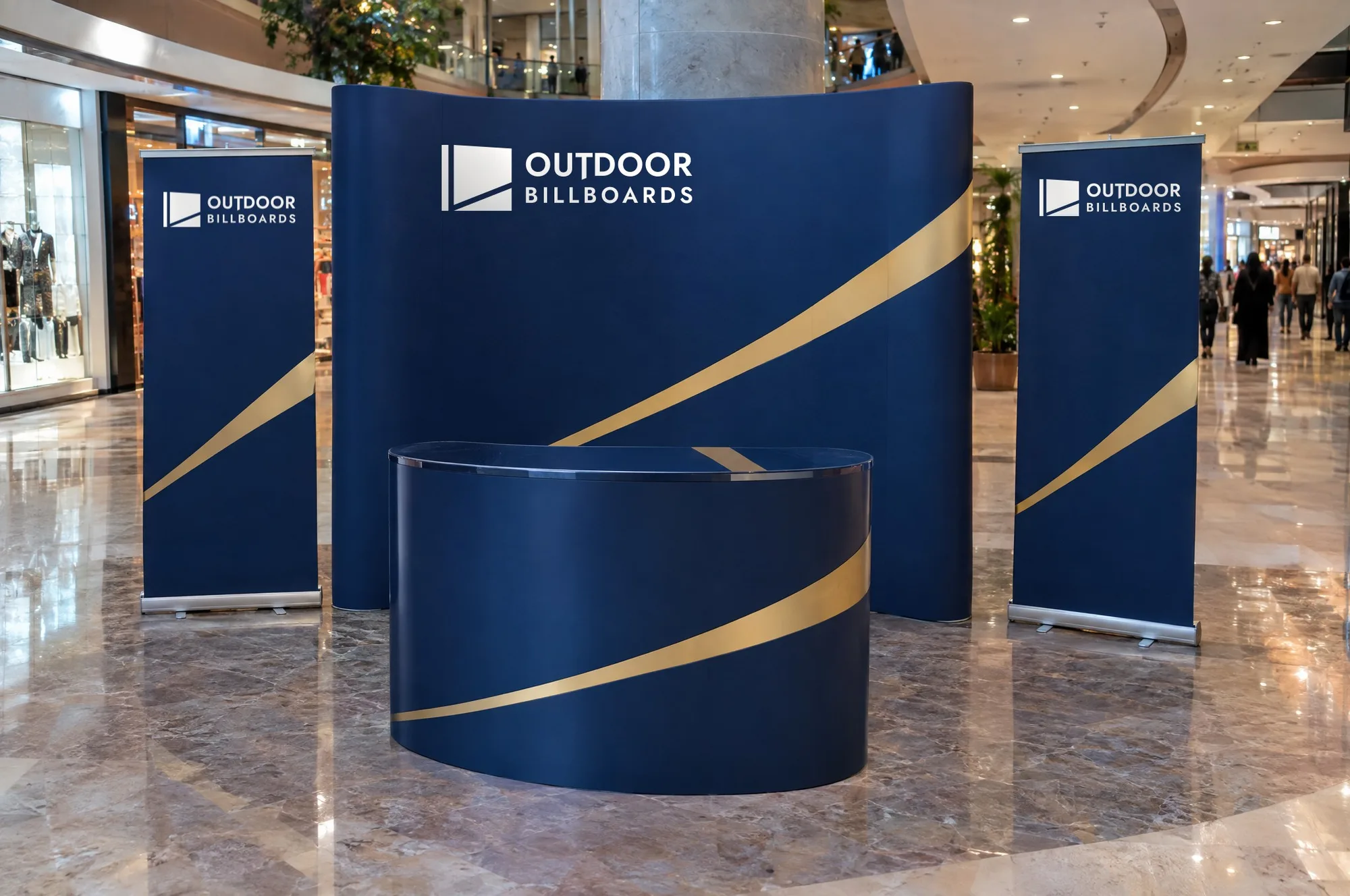 Promotional counter, backdrop and roll-up banners in a shopping mall, branded in navy and gold