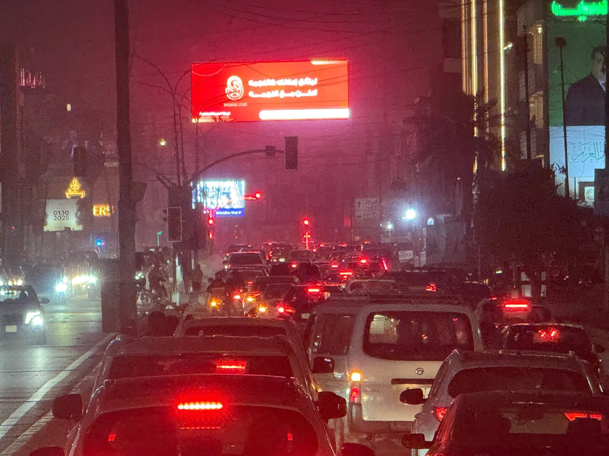Our LED screen at Al-Wathiq Square, Baghdad, glowing above evening traffic