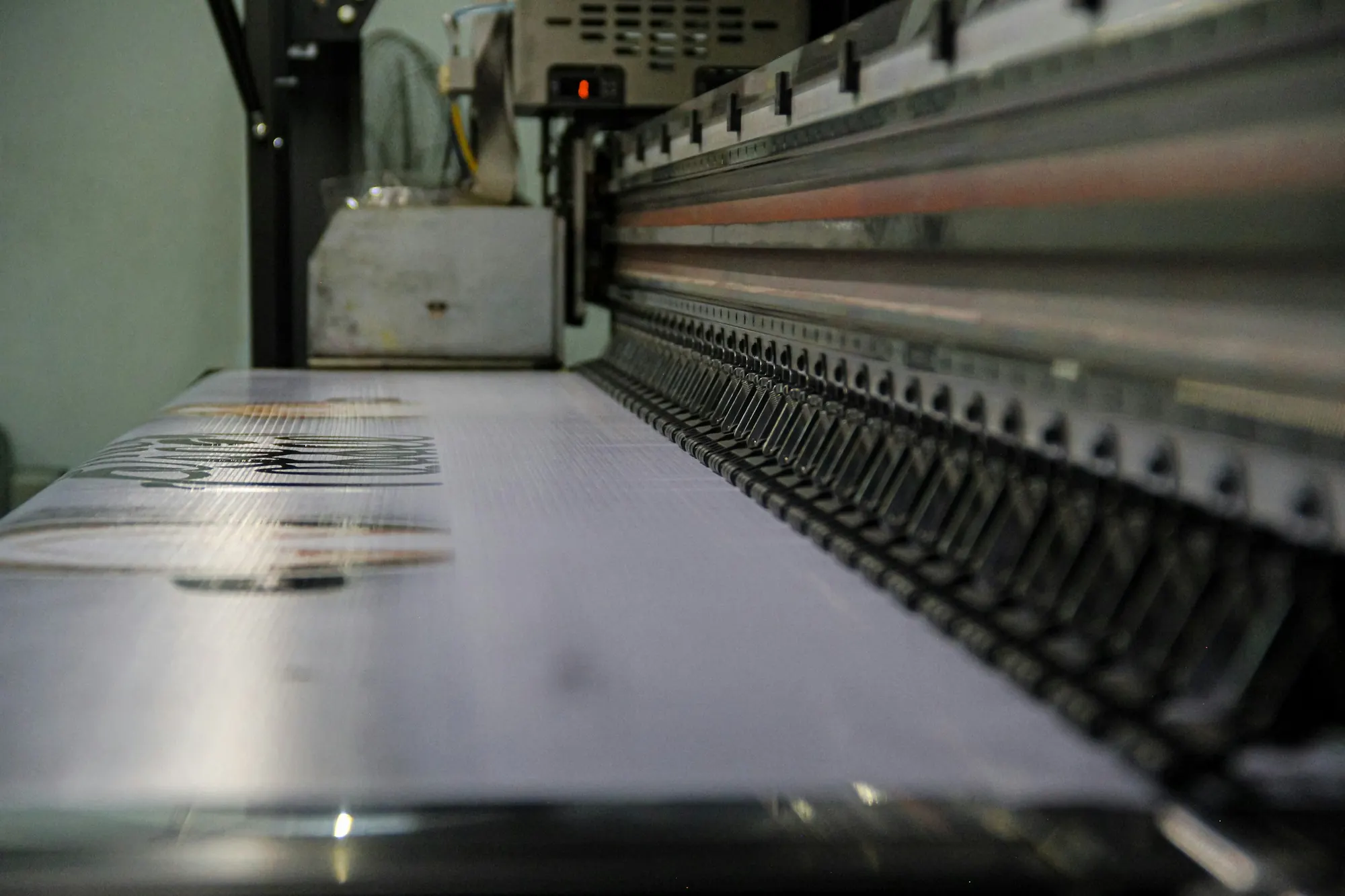 Printhead rail of a large-format printer over printed vinyl